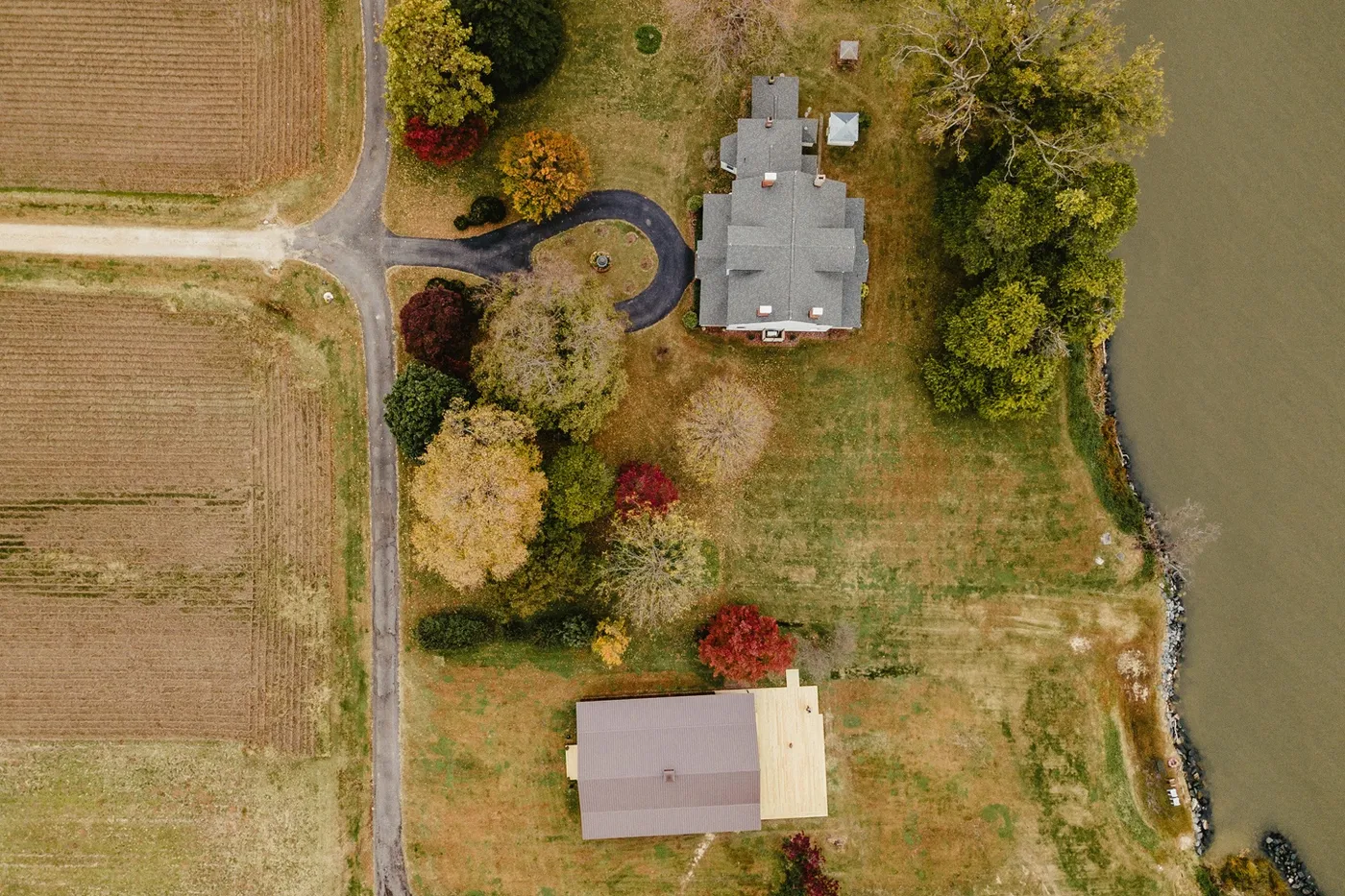 Aerial view of the reception barn at Lower Notley Hall Farm, next to the Wicomico River and surrounded by lush greenery.