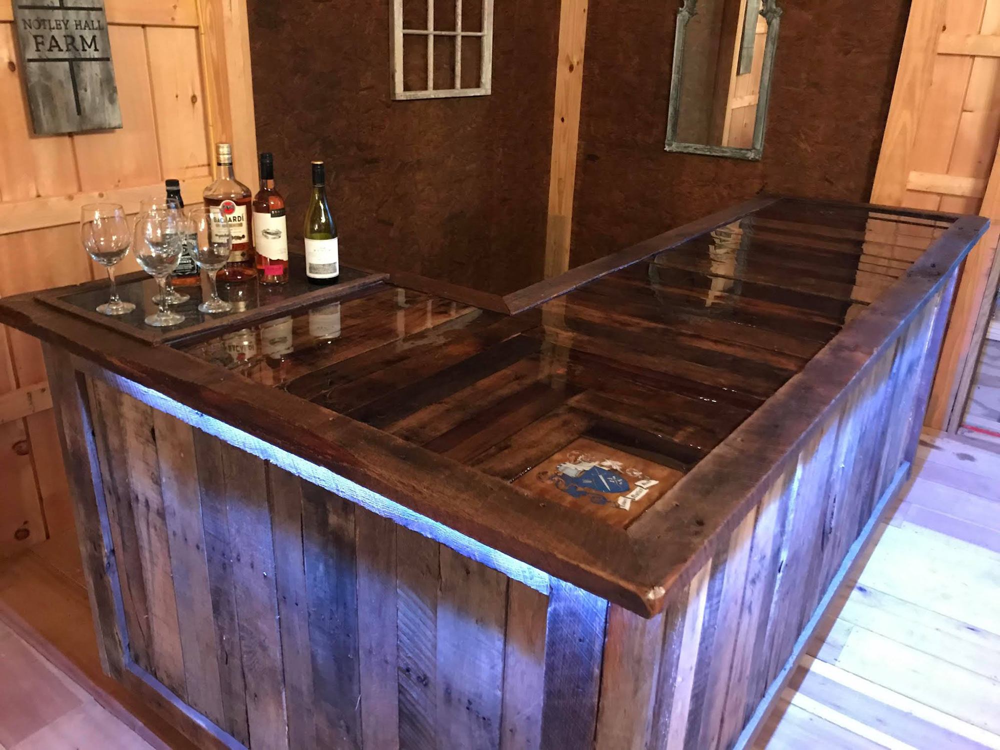A custom made bar on wheels with the Lower Notley Hall Farm coat of arms painted on the wood.