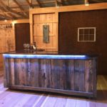 A custom made bar on wheels with the Lower Notley Hall Farm coat of arms painted on the wood.