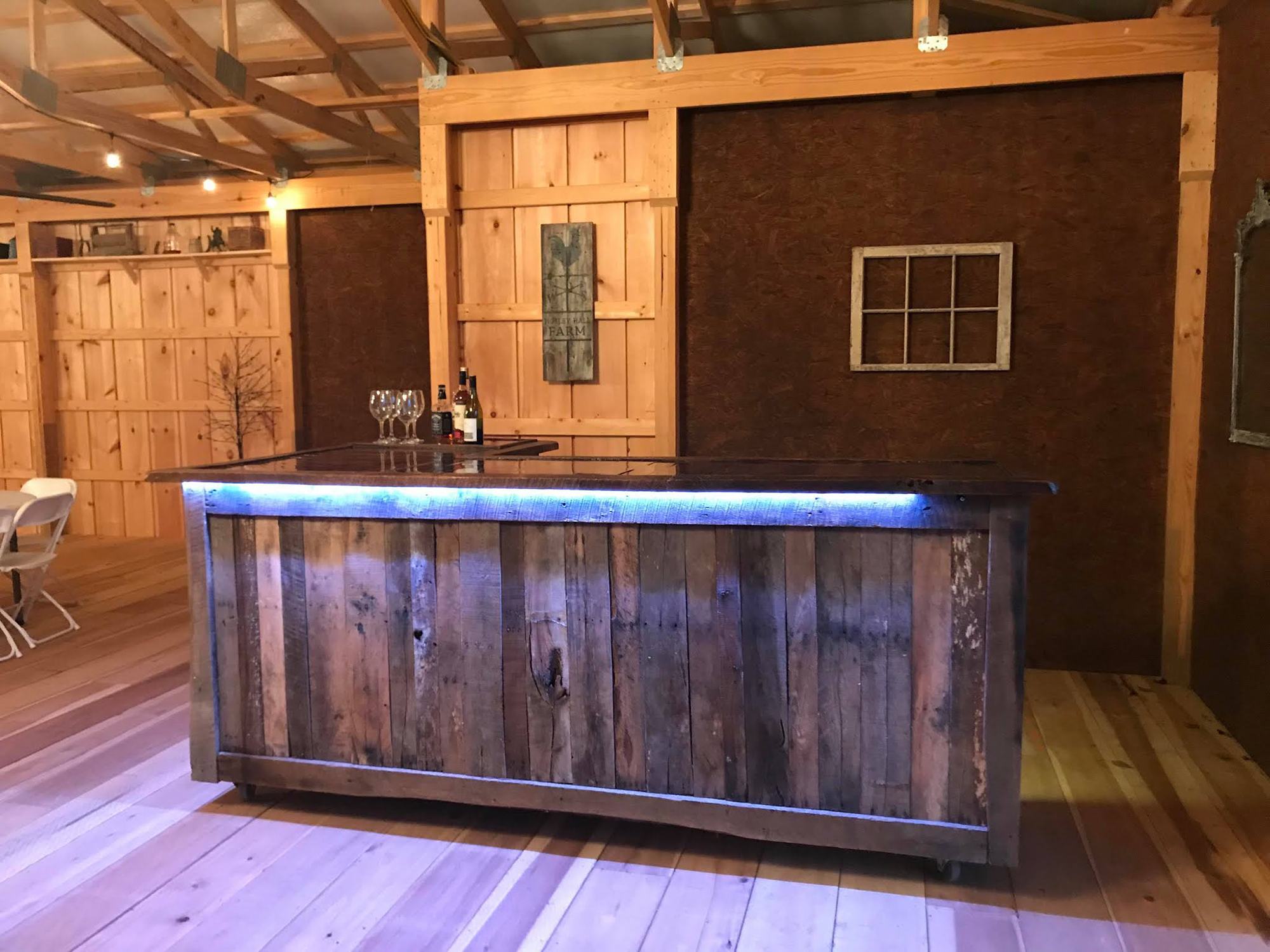 A custom made bar on wheels with the Lower Notley Hall Farm coat of arms painted on the wood.