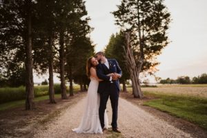 A bride and groom kiss in the lane.